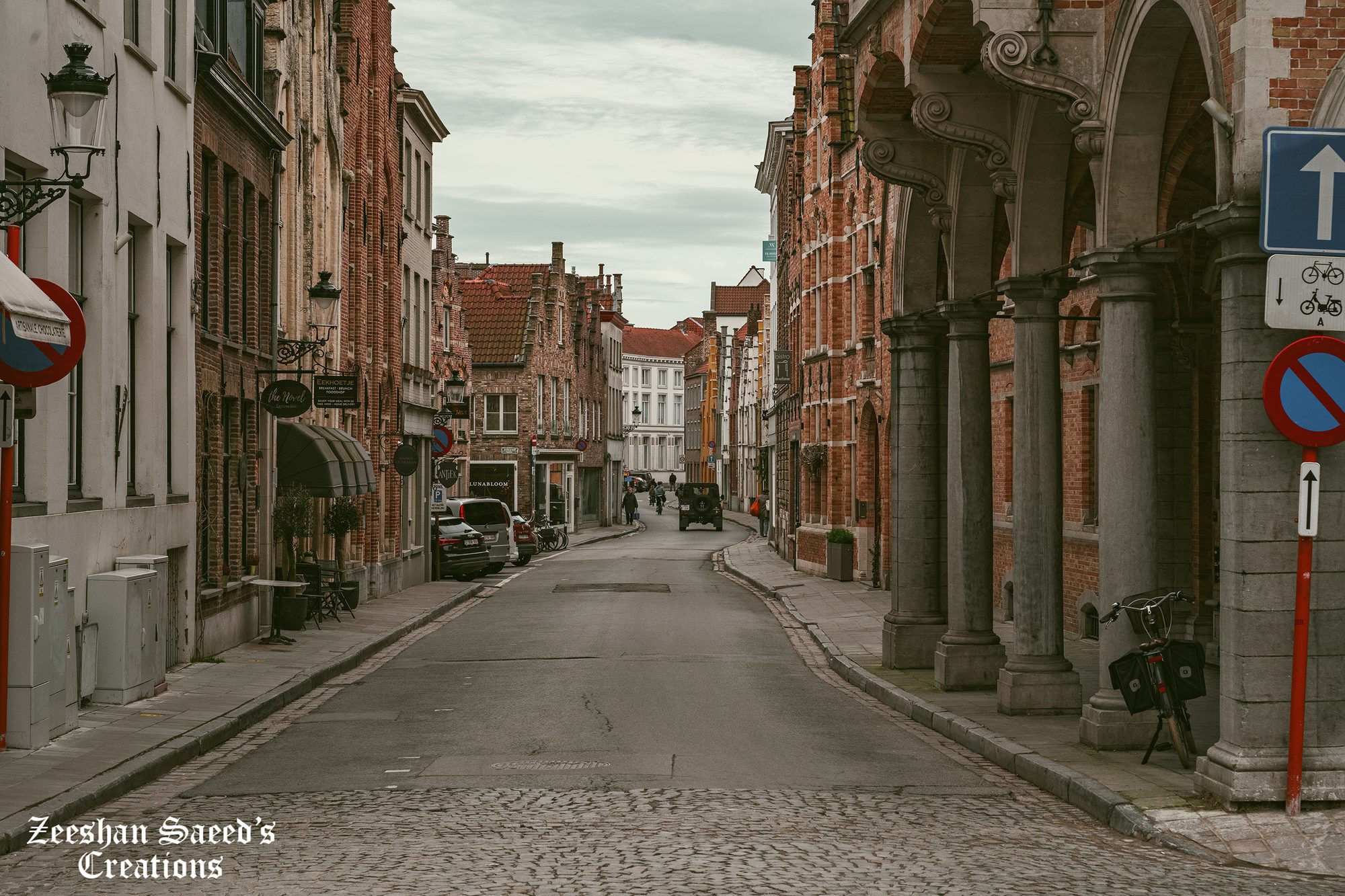 Quiet cobbled street with brick arcades, Bruges