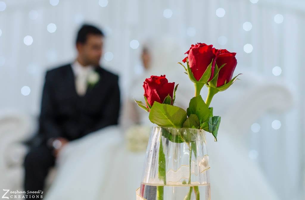 Red roses in a glass vase at my cousin's wedding